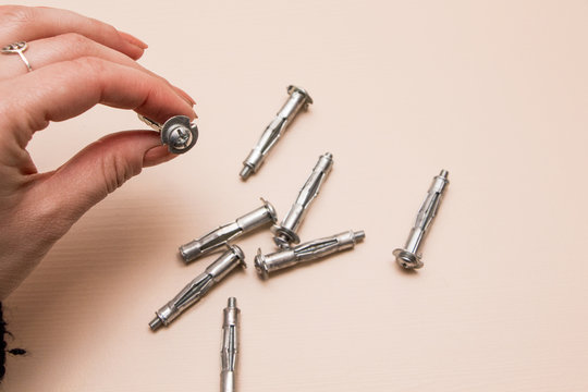 Wall plug or anchor or rawlplug in the hand  on a wooden background