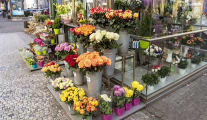 Fototapeta na wymiar Small florist shop display with roses and chrysanthemums for sale.