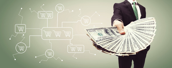 Online shopping theme with business man displaying a spread of cash