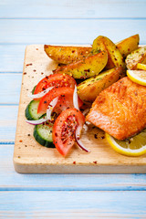 Grilled salmon with baked potatoes, asparagus and vegetable salad