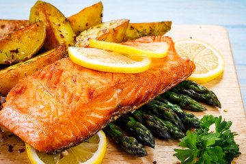 Grilled salmon with baked potatoes, asparagus and vegetable salad