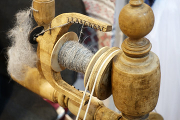 Antique wooden spinning wheel with yarn.