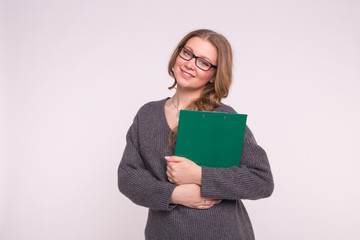 Portrait of calm smart young woman holding green paper folder on white background