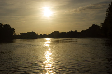 Naklejka premium the mouth of the river at sunset with trees near the coast of France