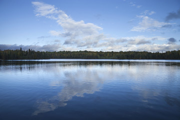 Blue sky and clouds over calm lake at dusk in northern Minnesota