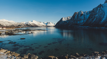 Obraz premium Panoramic view of beautiful winter lake with snowy mountains at Lofoten Islands in Northern Norway