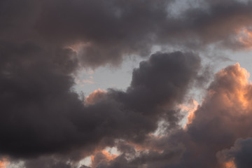 Naklejka na ściany i meble Storm clouds in the sunset light