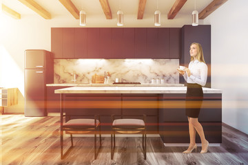Black and marble kitchen in studio flat, woman