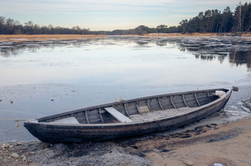 The fisherman boat on the river bank in winter. - 225065409