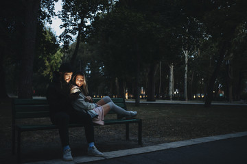 Couple chilling on bench with smartphone