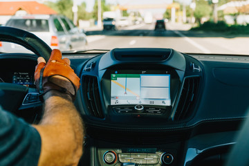 Dashboard View And GPS Map Of Modern Car With Hands Of Man Driver On Steering Wheel