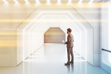 Fototapeta premium Futuristic white corridor, man with papers