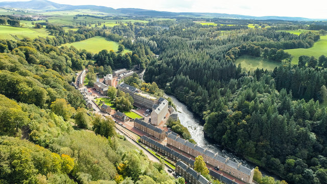 Aerial image of the village of New Lanark. A World Heritage Site in a deep valley next to the River Clyde.