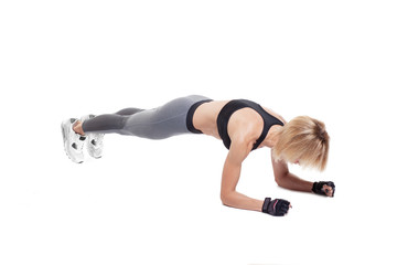 Sporty blonde female doing elbow plank exercise isolated on white background