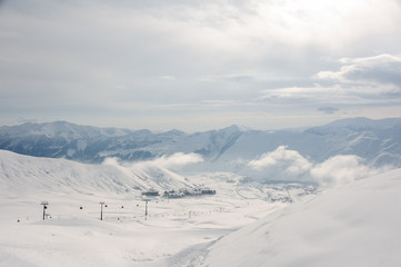 Pictoresque top view of cable car, small houses and hight mountains in Georgia, Gudauri