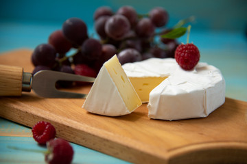 cheese camembert with a fork for cheese and grape