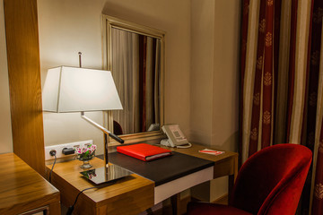 A room in the hotel is a workplace in the hotel and on the desk there is a folder, there is a telephone