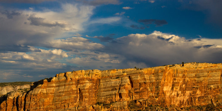Stunningly beautiful warm sunset light on the steep, sloping stone cliffs of Monument Canyon in Colorado National Monument