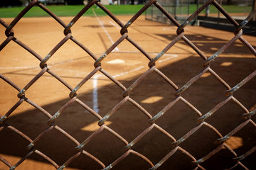empty baseball field behind fence