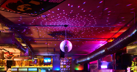 Disco ball, multi-colored background in the bar