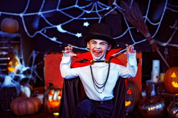 Portrait of a boy dressed in a costume of a vampire over grunge background. Halloween party.