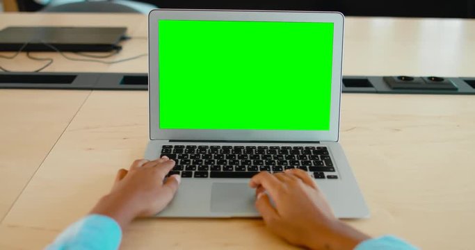 POV Young black African American woman sitting in the office, working on a laptop, green screen chroma key. 4K UHD 60 FPS SLO MO