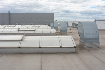 Flat roof with many large skylights and hydro insulation membranes on modern industrial hall or...