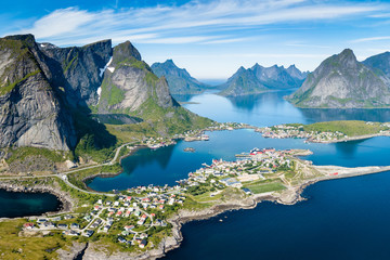 Reine Lofoten Norway, aerial view of Norwegian traditional fishing village above polar circle with blue sea and mountains during sunny arctic summer, famous for Reinebringen hike - obrazy, fototapety, plakaty