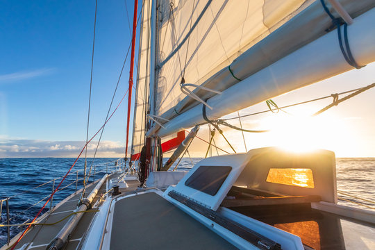 Sailing on sailboat yacht with beautiful sunset light clear blue sky and flat sea in Drake Passage, summer cruising, closeup of boat deck
