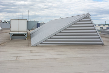 Flat roof with many large skylights and hydro insulation membranes on modern industrial hall or building