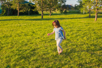 Little happy girl having fun in a summer park.
