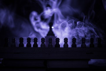 Obraz premium Chess board game concept of business ideas and competition or strategy ideas concept. Chess figures on a dark toned foggy background.