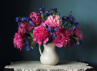 Peonies and irises in a white jug. Still life with flowers. © Masquerade