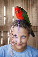 Happy young girl with parrot on her head in the zoo. © fotoyou