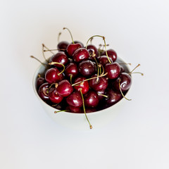 Naklejka na ściany i meble Bowl of fresh red cherries on white background