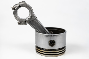A small combustion engine piston on a white table. Spare parts for mechanics.