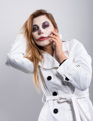 girl in a white coat on a white background with Halloween makeup