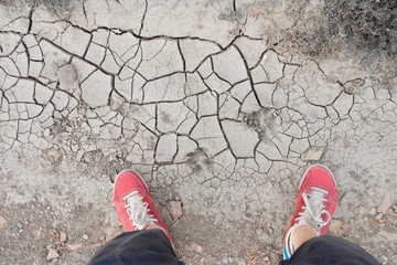 Fototapeta premium man standing on dry cracked soil