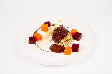 Beef cheeks with vegetables, roasted parsley root mousse , pearl barley, dark chocolate and demi glace sauce on a white background