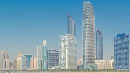 Foto op Plexiglas View of high skyscrapers on a corniche in Abu Dhabi stretching alongside the business center timelapse hyperlapse. © neiezhmakov