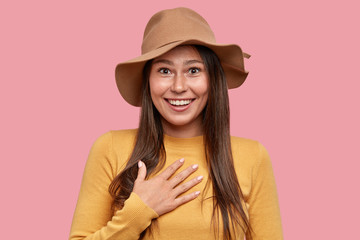 Emotional surprised freckled woman with positive expression keeps hand on chest, cant believe she...