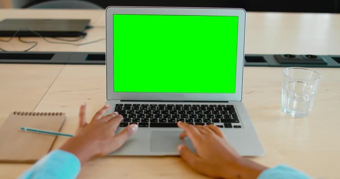 POV Young black African American woman sitting in the office, working on a laptop, green screen chroma key. 4K UHD 60 FPS SLO MO