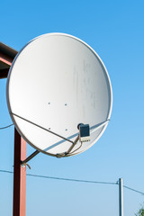 Large satellite dish antenna on the garden house pillar
