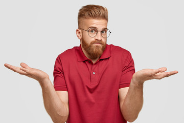 I know nothing. Handsome stylish hipster with thick ginger beard, spreads palms with questionned...