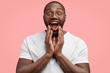 Horizontal shot of happy smiling African American teacher rejoices positive result of his student...