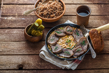 Sliced beef tongue in cast iron skillet, copy space