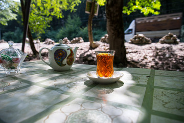 Eastern black tea in glass on a eastern carpet. Eastern tea concept. Armudu traditional cup. Sunset background. Selective focus