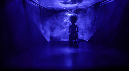 Creepy silhouette in the dark abandoned building. Horror about maniac concept or Dark corridor with cabinet doors and lights with silhouette of spooky horror person