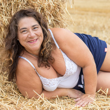 Mollige Frau mittleren Alters im Heu