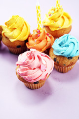 Tasty cupcakes on pinke background. Birthday cupcake in rainbow colors.